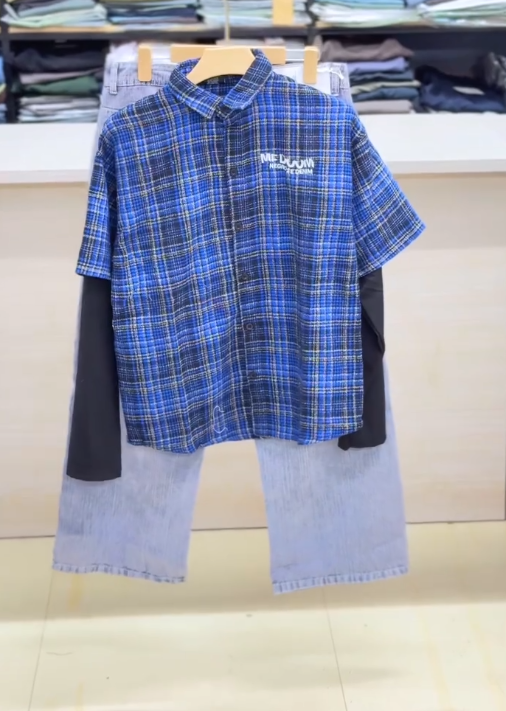 Effortless Layered Style: Casual Plaid Short-Sleeve Shirt Over Black Top with Light Blue Trousers