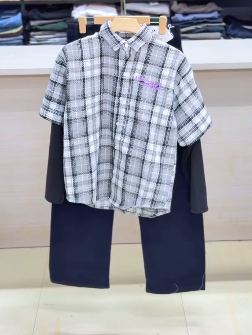 Effortless Layered Style: Casual Plaid Short-Sleeve Shirt Over Black Top with Light Blue Trousers