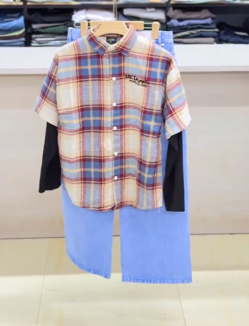 Effortless Layered Style: Casual Plaid Short-Sleeve Shirt Over Black Top with Light Blue Trousers