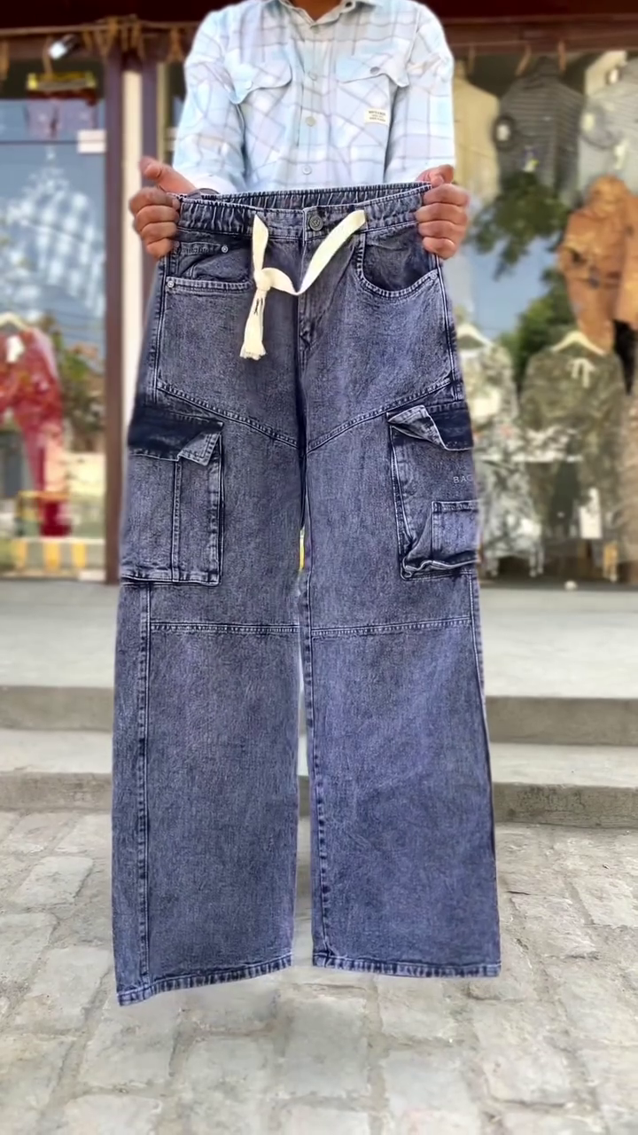These blue denim jeans feature distinctive white panel detailing down the front of the legs and are often styled as upcycled or Y2K-inspired fashion.