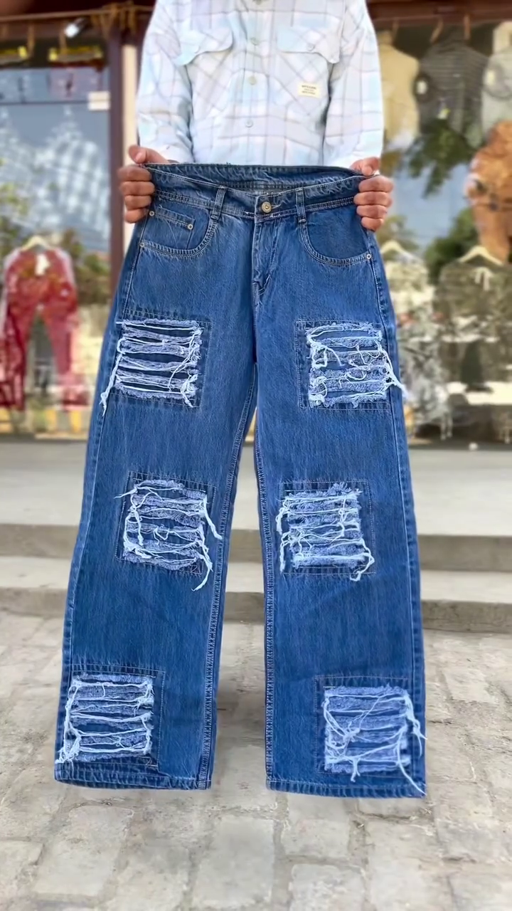 These blue denim jeans feature distinctive white panel detailing down the front of the legs and are often styled as upcycled or Y2K-inspired fashion.